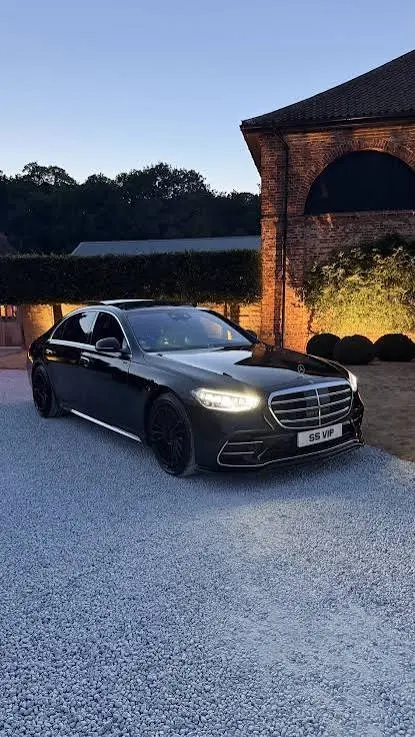 Chauffeur service NYC professional chauffeur opening a car door