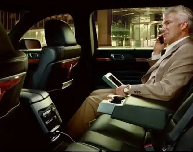 Corporate car service NYC chauffeur assisting an executive with luggage