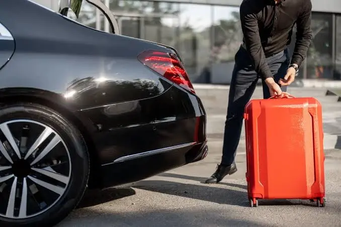 LaGuardia airport car service chauffeur standing beside a private car