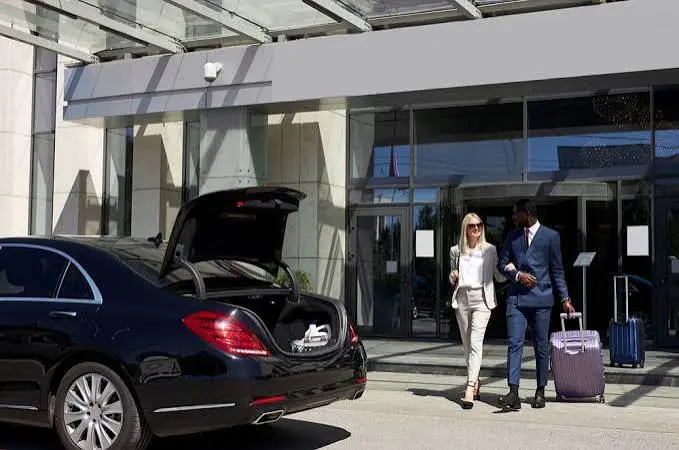 Newark airport car service chauffeur standing beside a private car